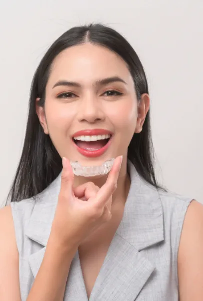 Smiling woman putting in a clear aligner
